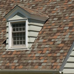 House with tan siding, two dormers with tan windows and Owens Corning Aged Copper shingles.