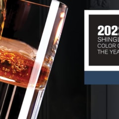 Montage with leather, bourbon pouring into a rocks glass with a cozy fire in the background. Layered over the montage image is a Bourbon shingle swatch with “2022 Shingle Color of the Year” text.