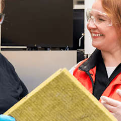 Two women in a Paroc Research and Development Laboratory, inspecting a piece of PAROC insualtion