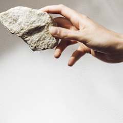 a hand holding a piece of stone