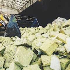 a plant worker inspecting a piece of stone wool