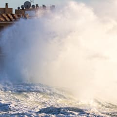 Ocean waves crashing into a coastal apartment building