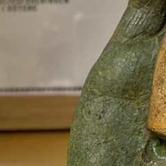 en hand av sten med ett hjärta av guld