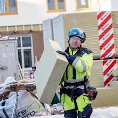 En person i arbejdstøj bærer en isoleringsplade af PAROC Tento, Klimaplade ZERO.