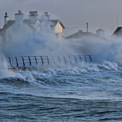 Ocean waves crashing into a coastal apartment building