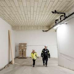 Två personer går i ett parkeringsgarage där PAROC CGL 20cy är installerat i taket. 