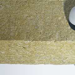 Stone wool insulation material with a pair of headphones, illustrating its use in acoustic insulation.