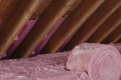 Attic insulation installation using R-30 unfaced rolls in rafters