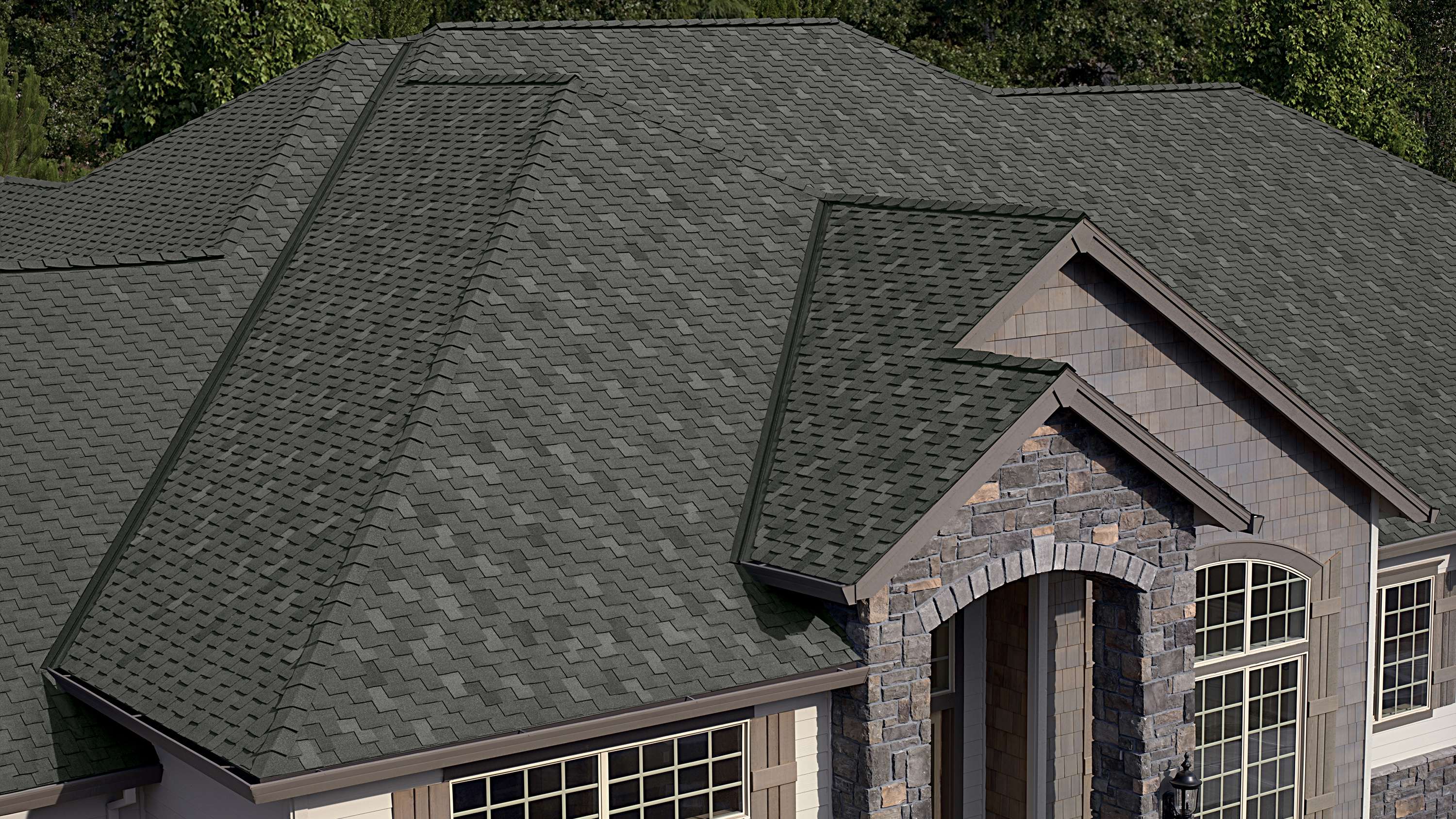 Woodmoor® Granite greenish dark gray shingles on a tan home with gray stone accents