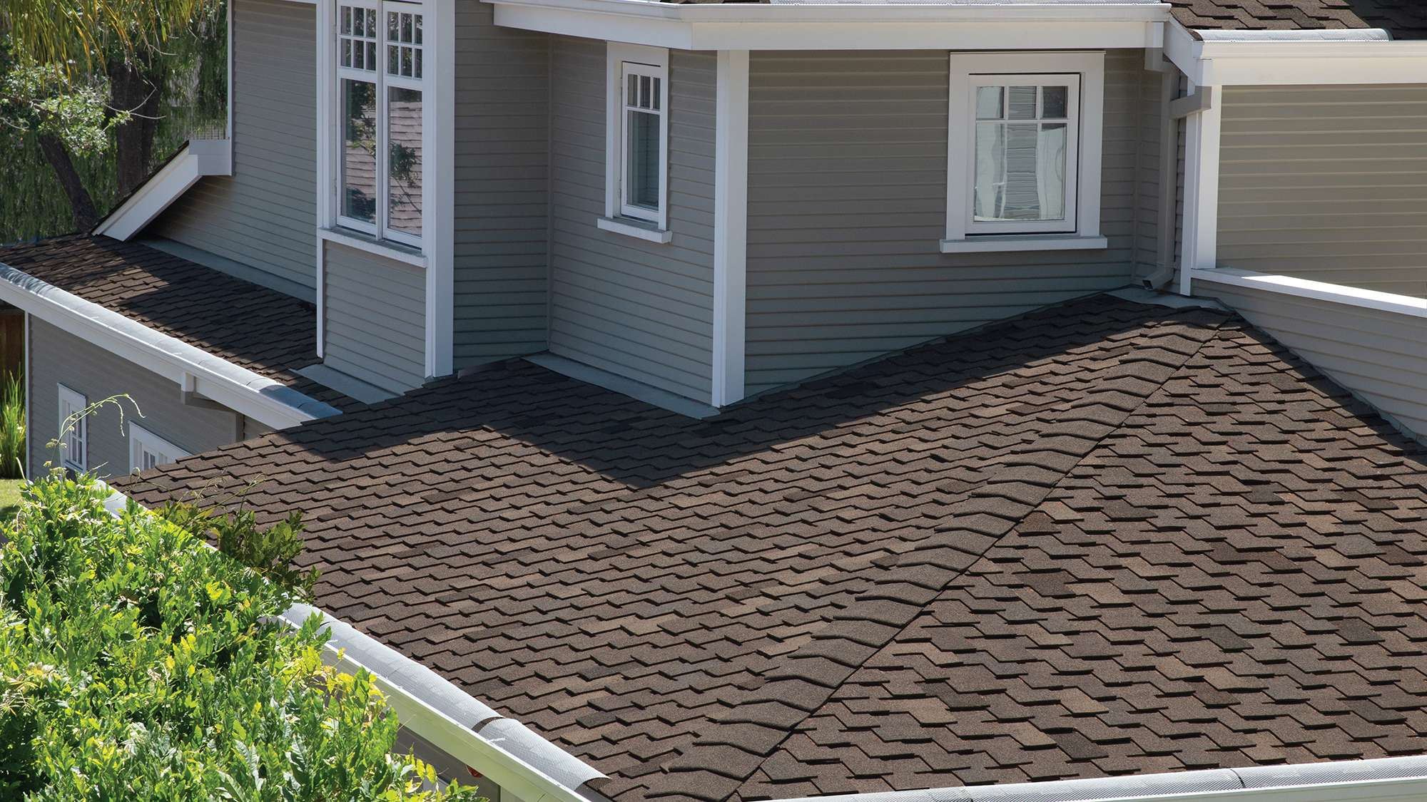Woodmoor® Chestnut brown shingles on a tan two-story home