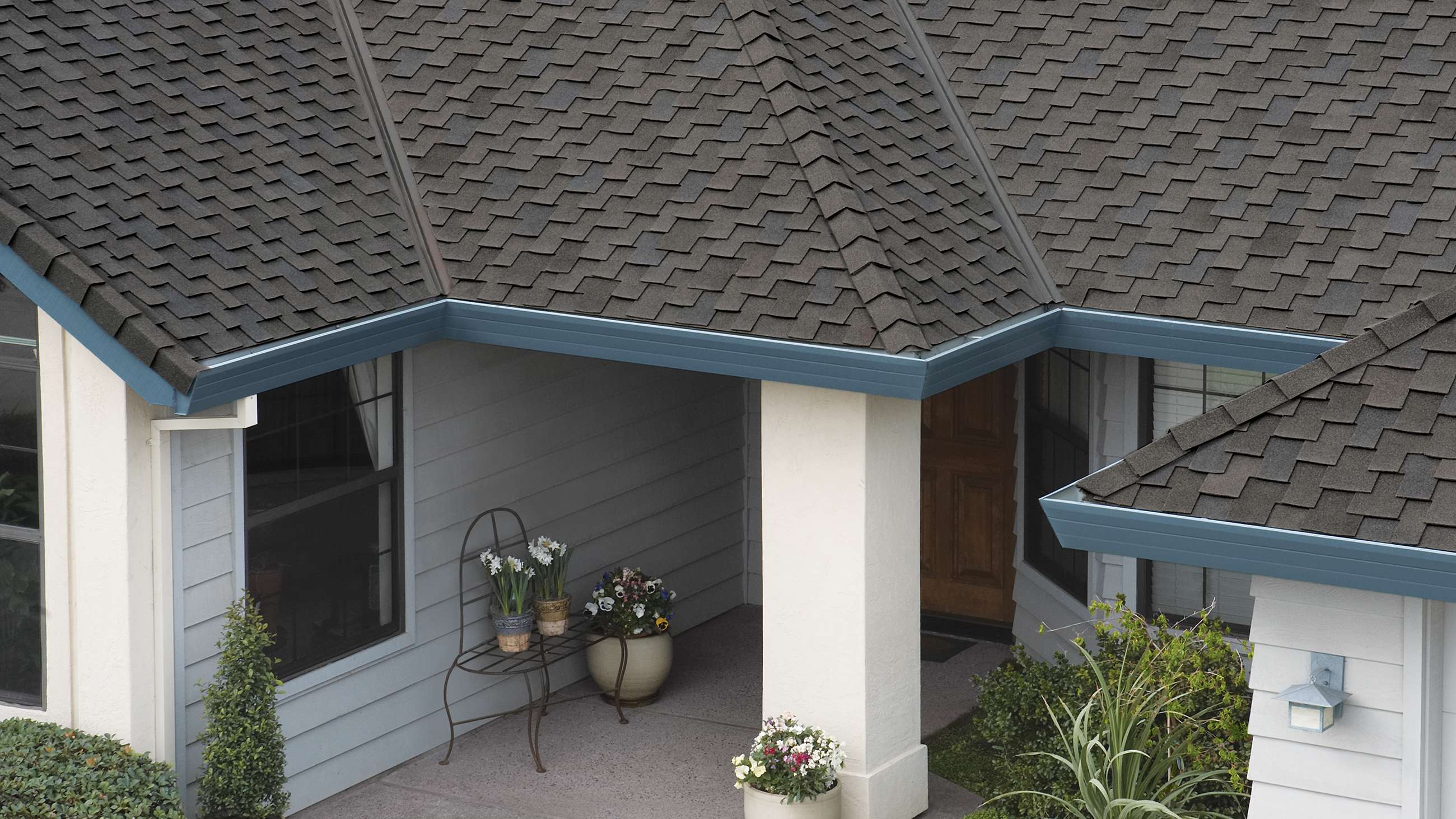 Woodcrest® Mesquite grayish brown shingles on a white house