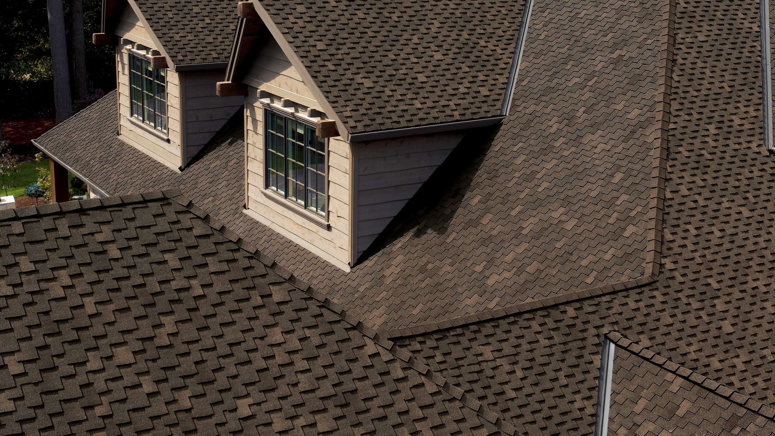 Woodmoor® Chestnut brown shingles on a tan two-story home
