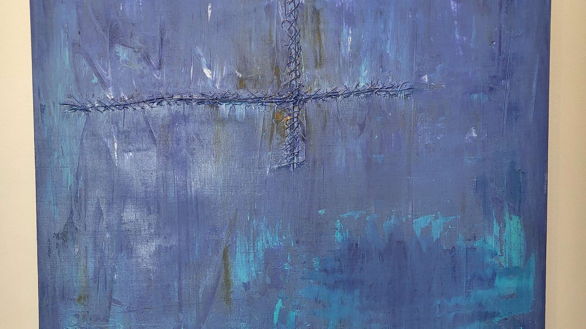   Abstract painting with textured blue and purple hues, a cross-like mark in the center, and dark base tones.