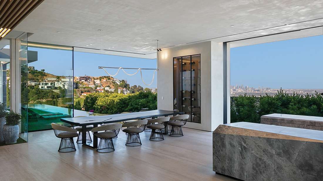 Modern open-concept dining area with floor-to-ceiling glass walls, panoramic city view, sleek dining table with designer chairs, and contemporary lighting fixtures.