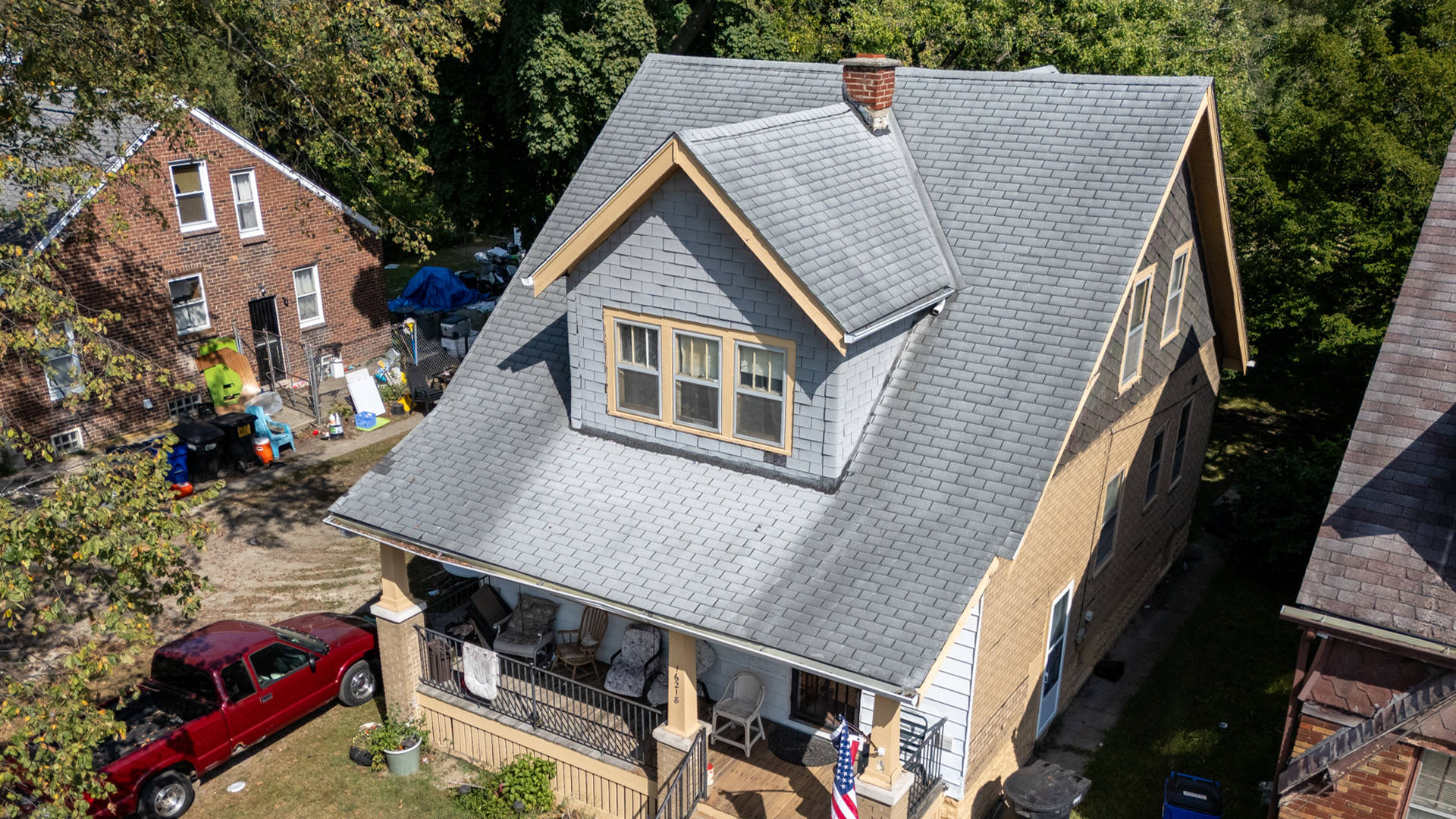 Tan multistory home with date 3tab grey roof with algae.
