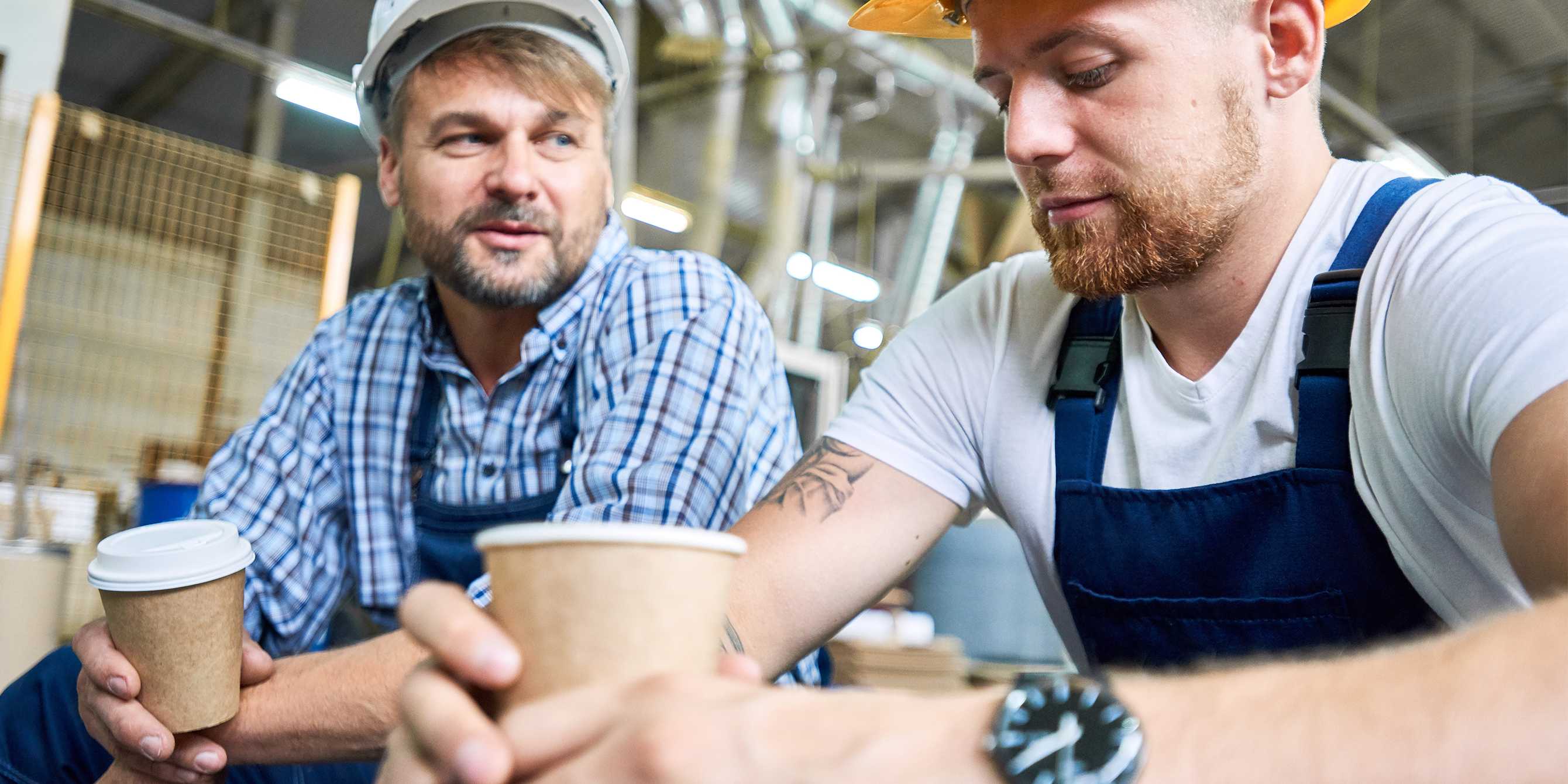 Two construction workers having coffee