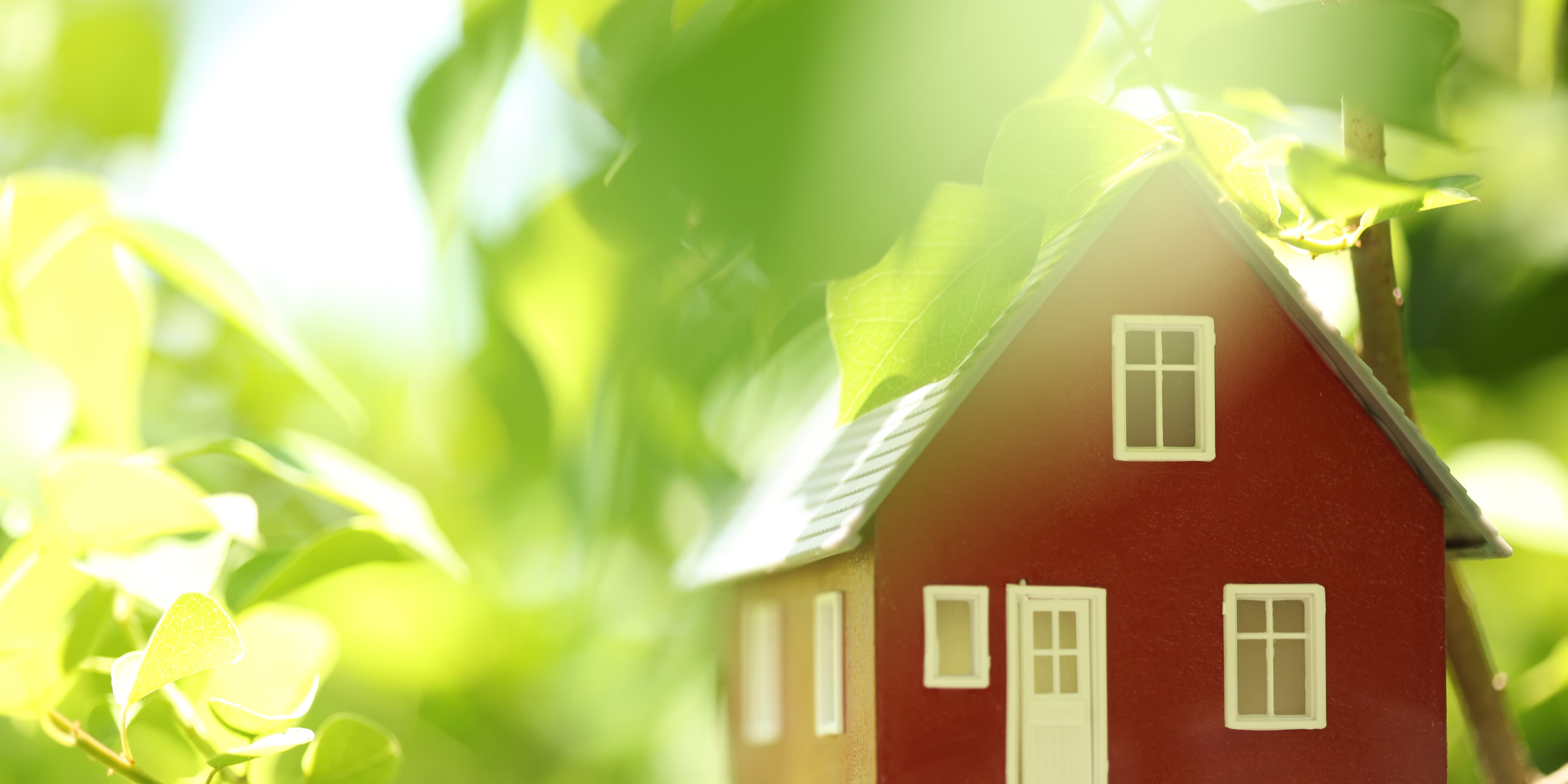 Et lille rødt hus med hvide knuder ligger i et træ