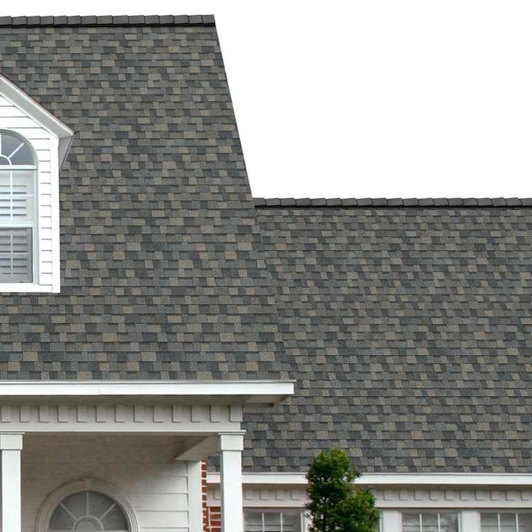 The porch entryway to a home depicts how well TruDefinition® Duration® Peppercorn dark gray, tan, brown and light gray shingles pair with the white horizontal paneling and a woodgrain door with white columns.