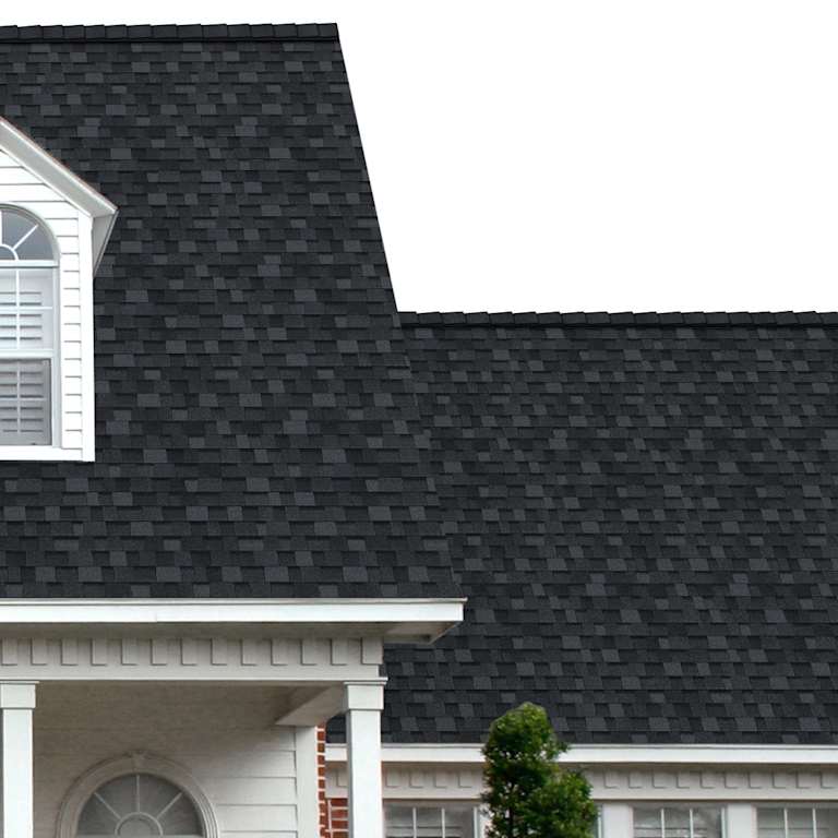 The porch entryway to a home depicts how well Onyx Black TruDefinition® Duration® dark gray and black shingles pair with the white horizontal paneling and a woodgrain door with white columns.