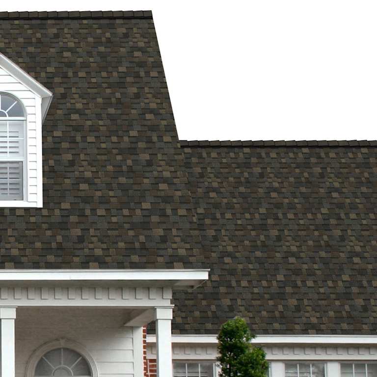 The porch entryway to a home depicts how well Black Sable TruDefinition® Duration® FLEX® brown, taupe, dark gray and black shingles pair with the white horizontal paneling and a woodgrain door with white columns.