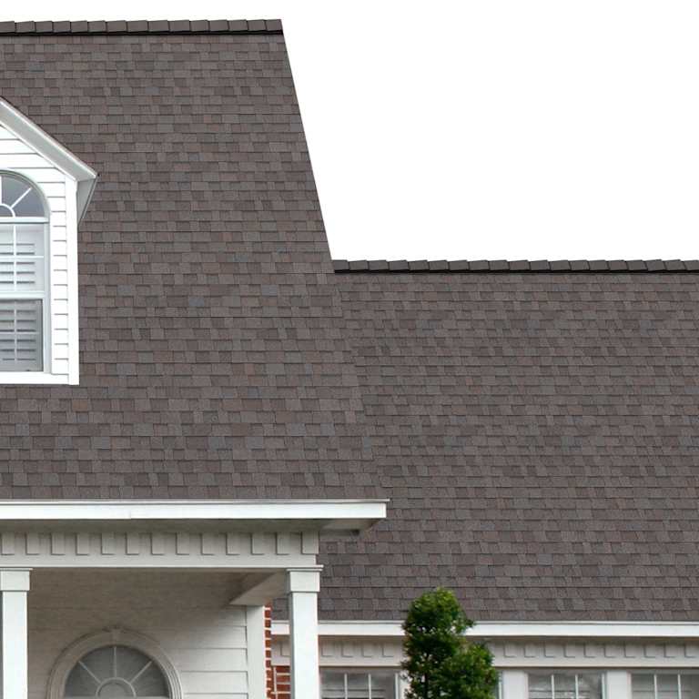 La entrada del porche de una casa muestra cuán bien las tejas de color gris amarronado cálido Rolling Stone TruDefinition® Duration® COOL Plus se combinan con el panel horizontal blanco y una puerta símil madera con columnas blancas.