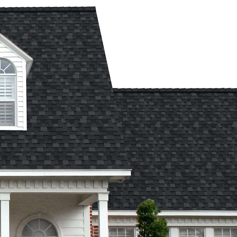 The porch entryway to a home depicts how well Onyx Black TruDefinition® Duration FLEX® black shingles pair with the white horizontal paneling and a woodgrain door with white columns.