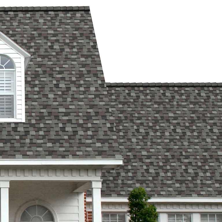 The porch entryway to a home depicts how well Mountain Pine TruDefinition® Duration® green, light green-gray, brown, and black shingles pair with the white horizontal paneling and a woodgrain door with white columns.