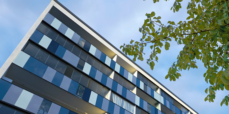 A building seen from beneath with the sky in the background.