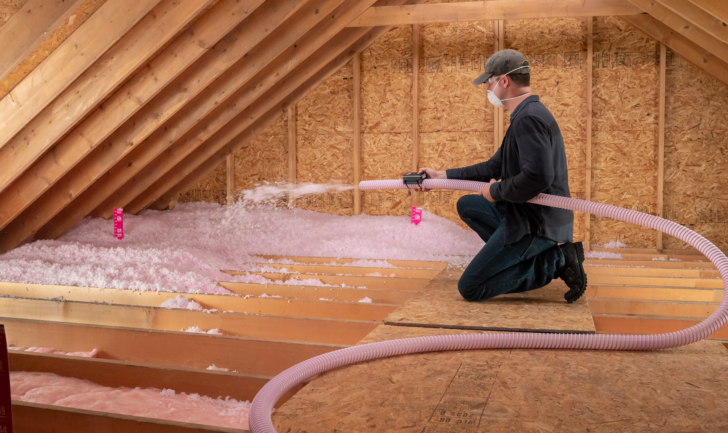 AttiCat Insulation being blow into the attic floor by roofing contractor.