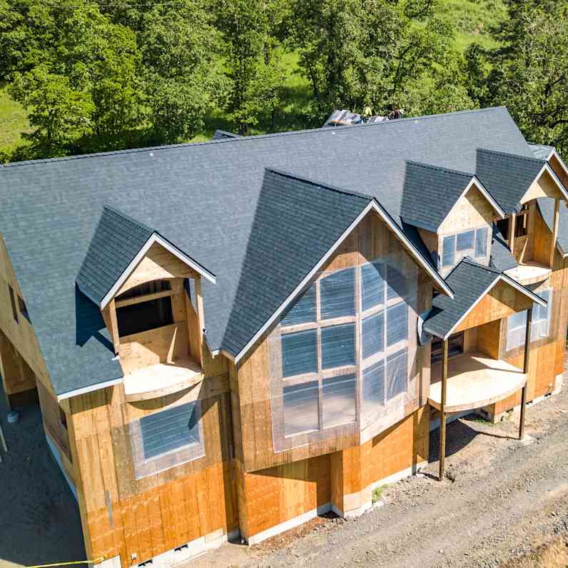 Aerial view of Mark Worman's home that is partially finished with exposed walls and a beautiful finished rooftop in Duration Onyx Black from Owens Corning