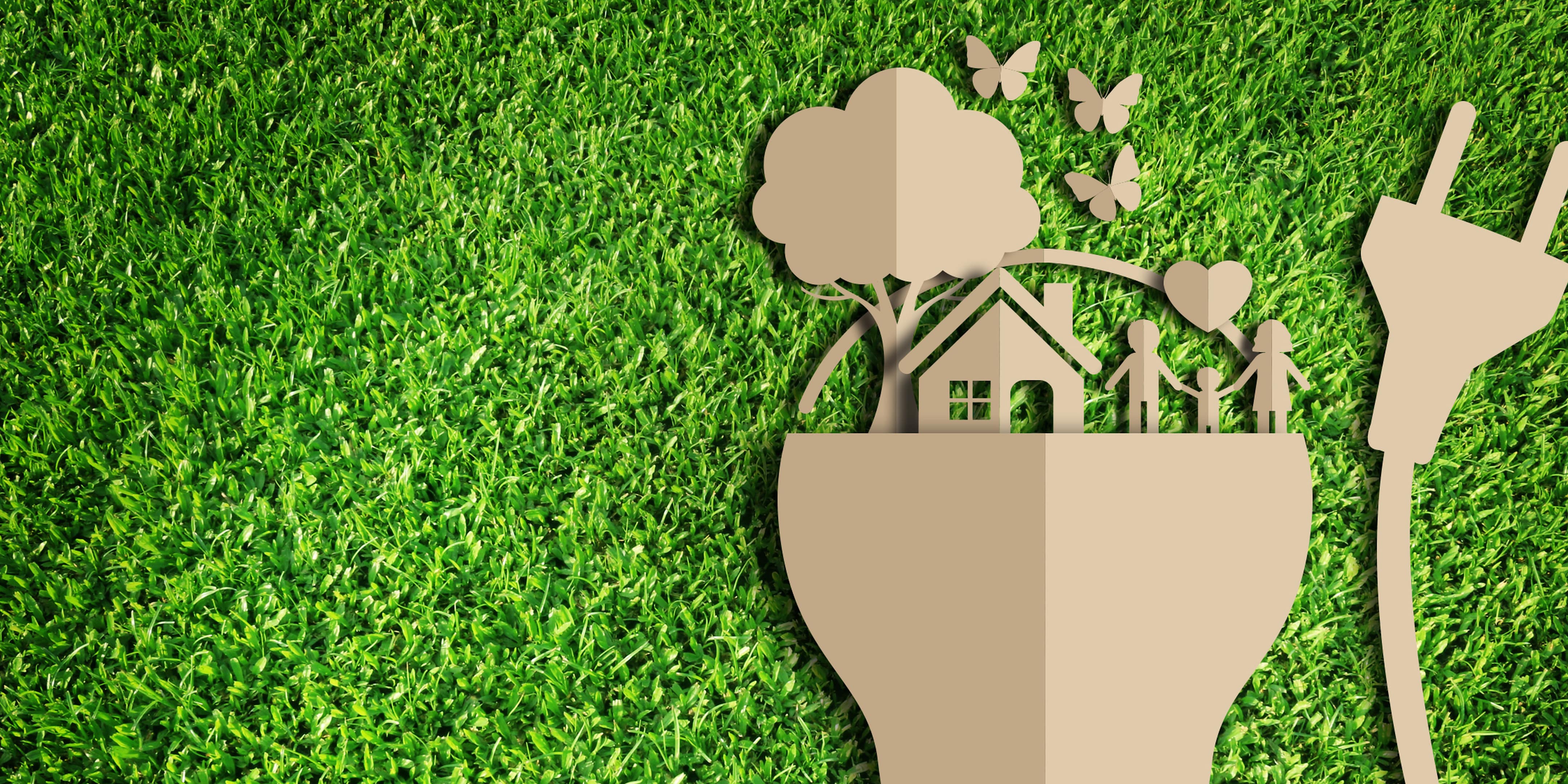 En illustration i papp där en familj står intill sitt hus