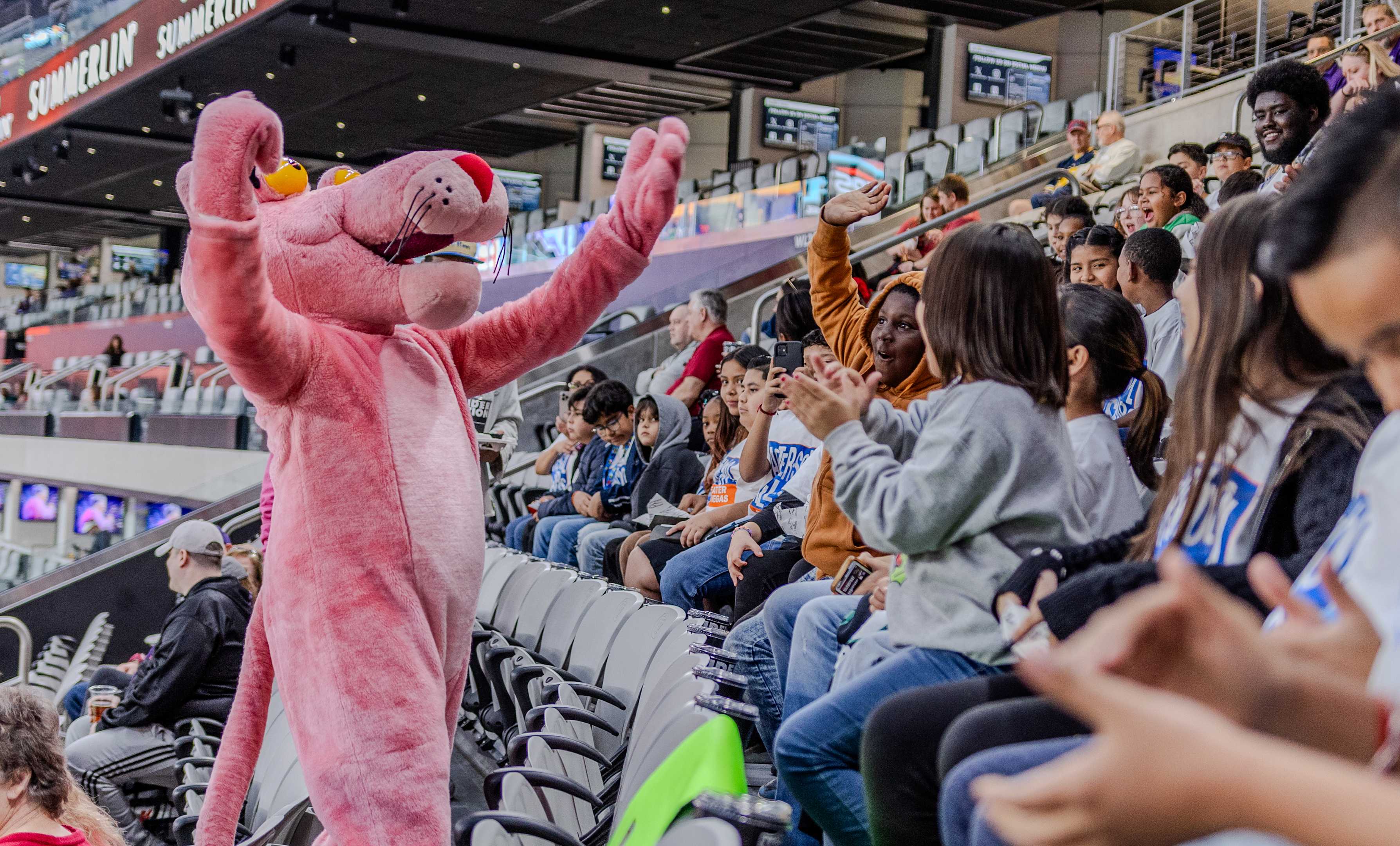 Pink Panther mascot in the stands of the football stadium encouraging fans to cheer.