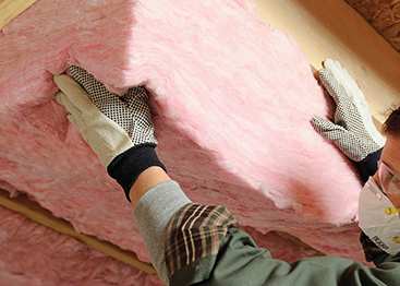 A contractor installing insulation