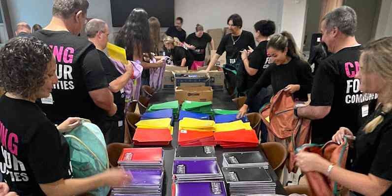 Photo of people working together assembling back to school kits