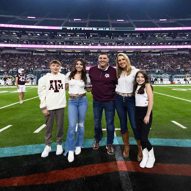 A family of 5 standing on in centerfield being honored as the military family from the Owens Corning Foundation and SRS Raise the Roof Foundation.
