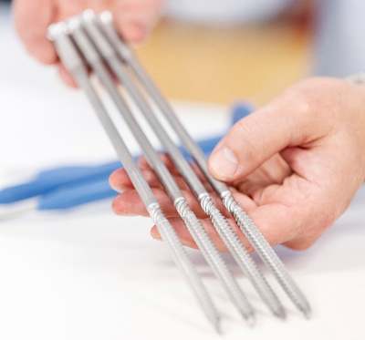 En person håller PAROC ZEROfix nya skruvar i händerna