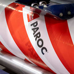 a roll of plastic packaging that is connected to a manufacturing line in a factory