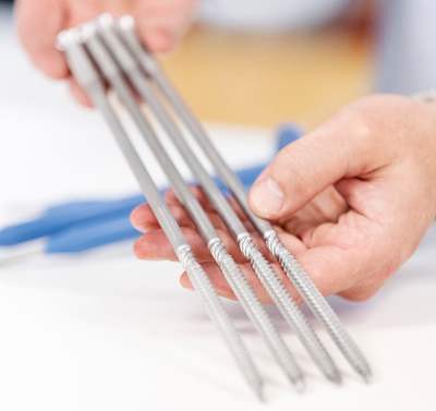 En person holder PAROC ZEROfix nye skruer i hænderne