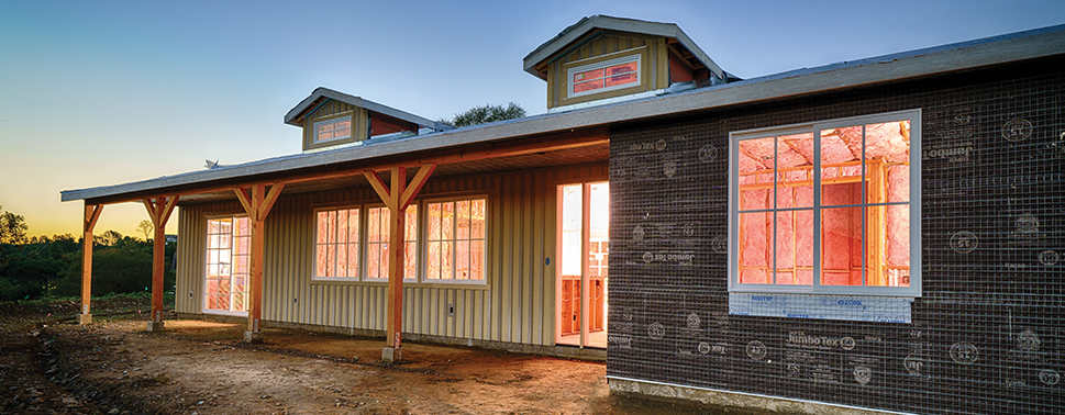 House under construction photograph with text that says "Attention homebuilders! Build better. Earn more. And grow with Owens Corning". 