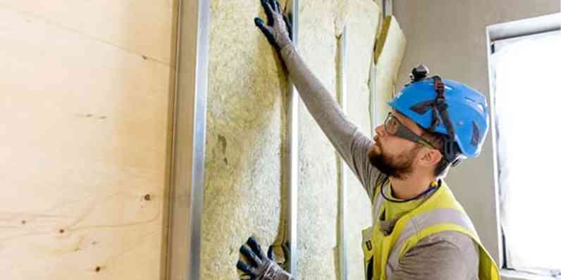 a man removing used stone wool from a wall for recycling