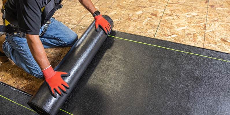 RhinoRoof® Anchor Sheet being unrolled onto the roof deck.