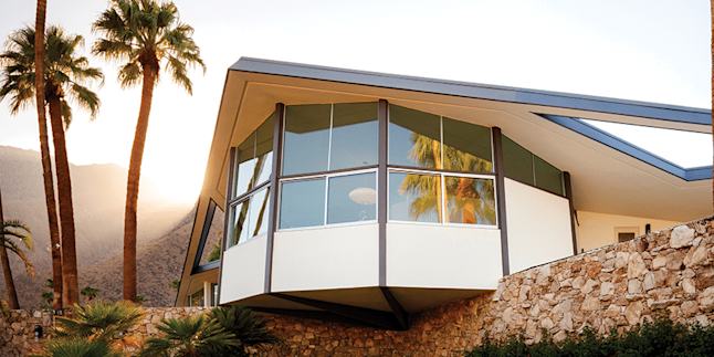 Photo of a house with windows and palm trees