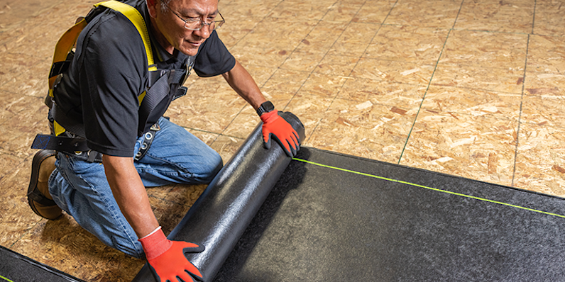 Hoja Anclada desplegándose durante el proceso de instalación sobre una cubierta de techo.