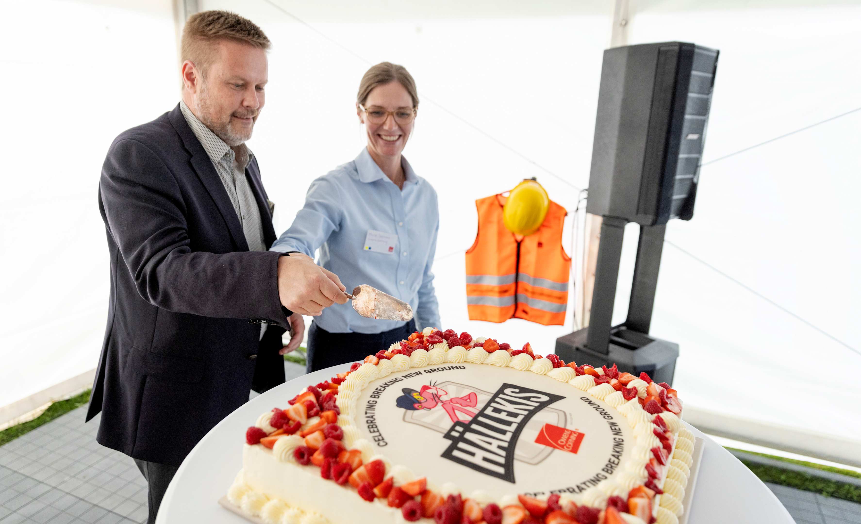Jari Airola, Vice President and Managing director, insulation Europe and Marie Stensson, Plant Leader Hällekis are cutting the cake to celebrate the ground breaking in Hällekis. 
