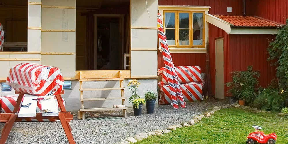 En familiesammenkomst i gården til et hus, der er ved at blive renoveret med Paroc-produkter.