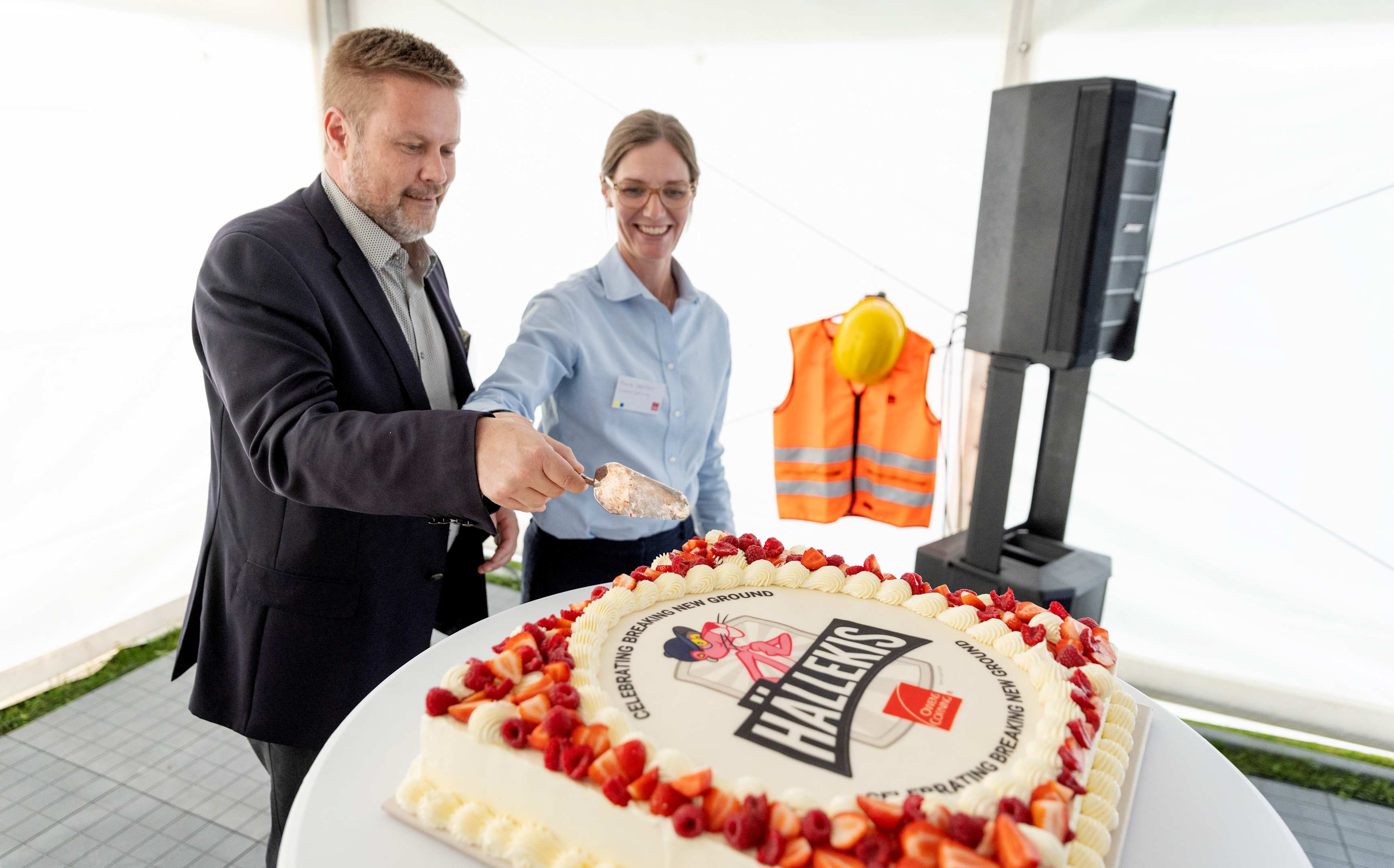 Jari Airola, Vice President og Managing Director, isolation Europe og Marie Stensson, Site Manager Hällekis skærer det første stykke kage for at fejre investeringen i Hällekis.
