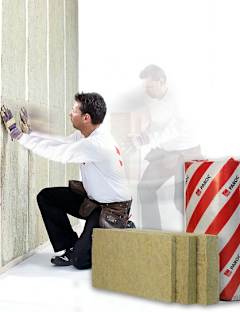 En mann isolerer med PAROC Steinull