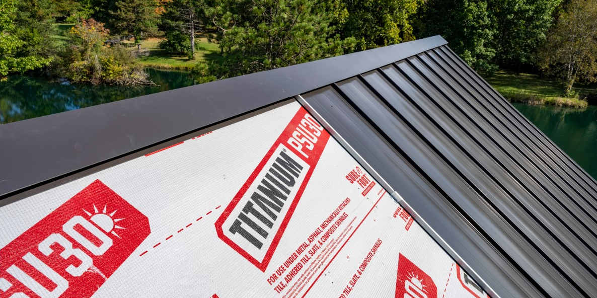 Close up of a partially installed black metal panel roof, revealing Titanium PSU30 underlayment.