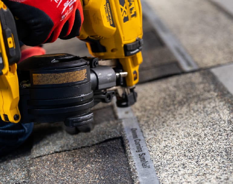 Duration Shingles being nailed to a roof deck with a yellow dewalt nail gun.