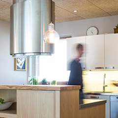 Et køkken med hvide skabe og mennesker sløret.